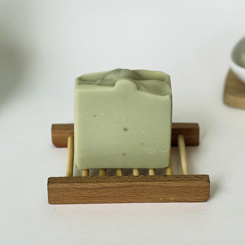 Nuada Naturals Deep Forest green clay soap bar sitting on a wooden tray