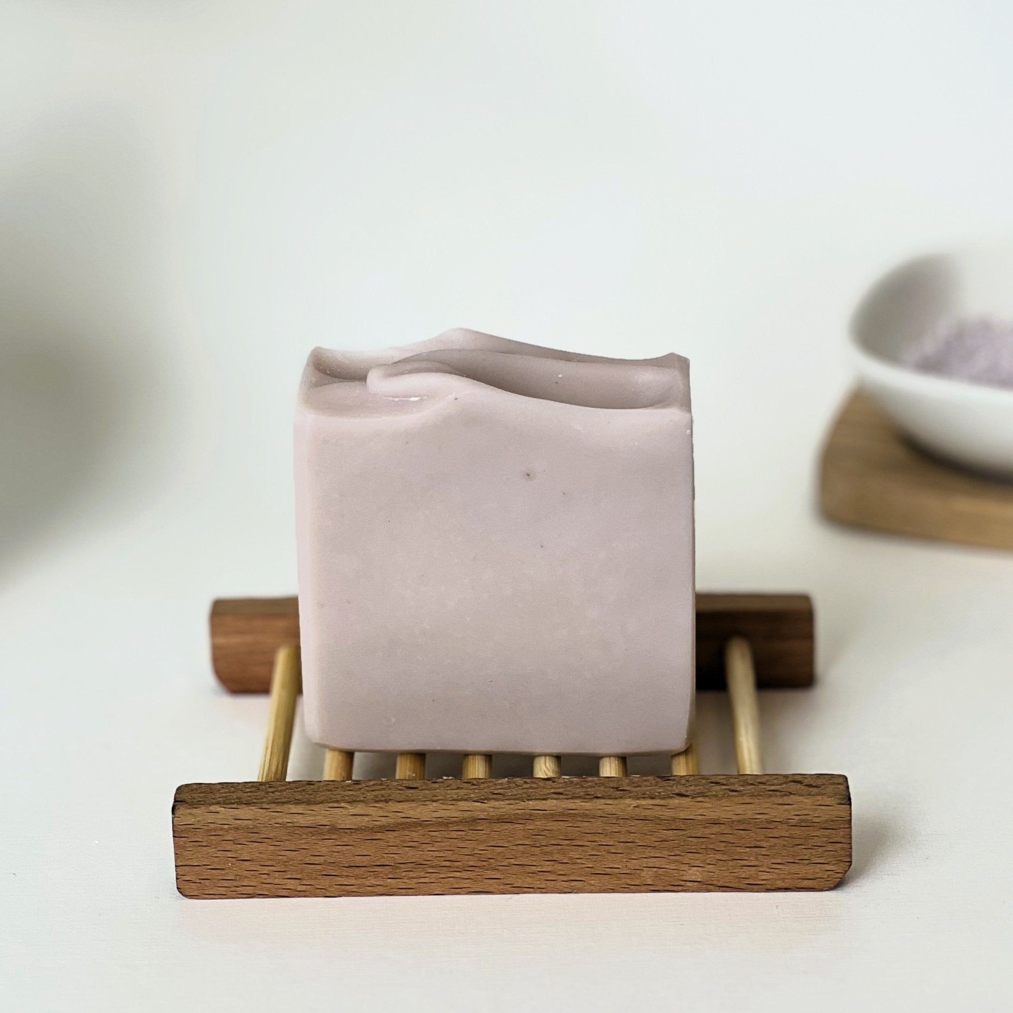 Nuada Naturals Dusk purple clay soap bar resting on a wooden soap dish
