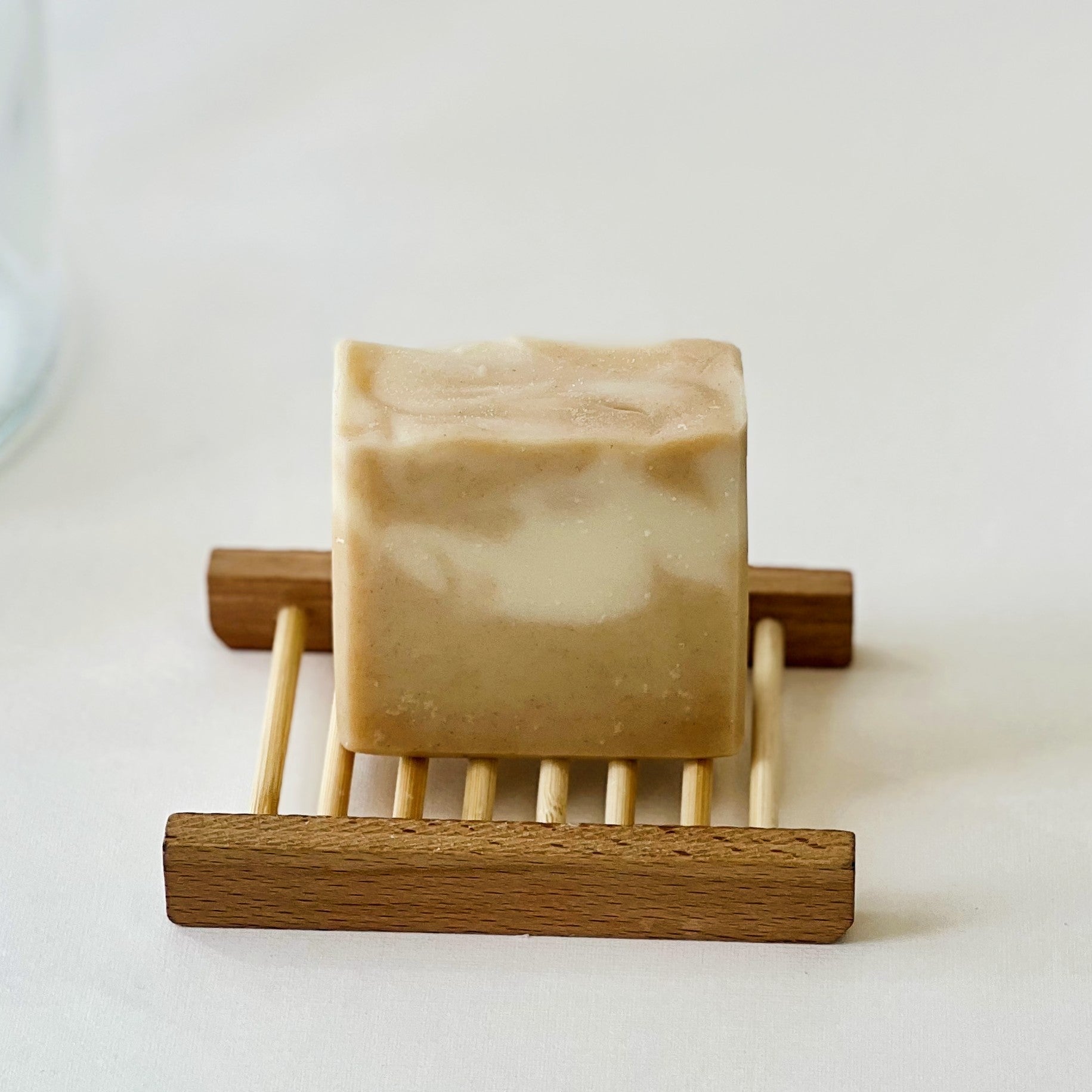 Nuada Naturals Golden Hour natural soap bar with light swirl resting on wooden tray