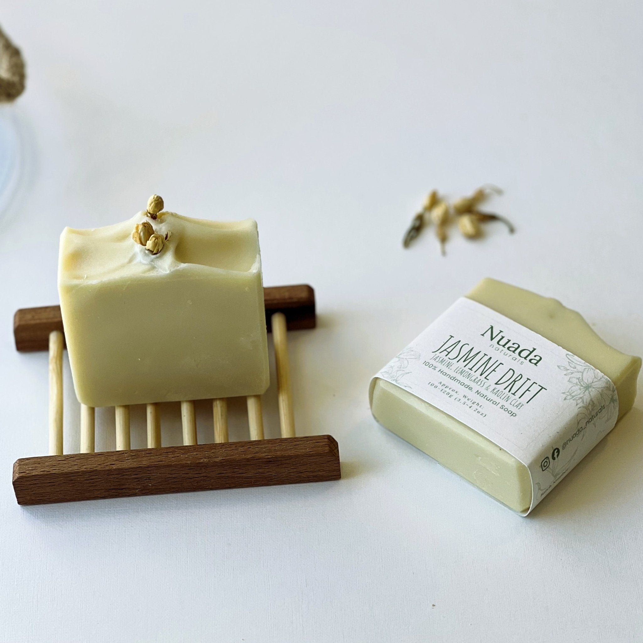 Nuada Naturals Jasmine Drift soap bar on wooden tray next to wrapped soap