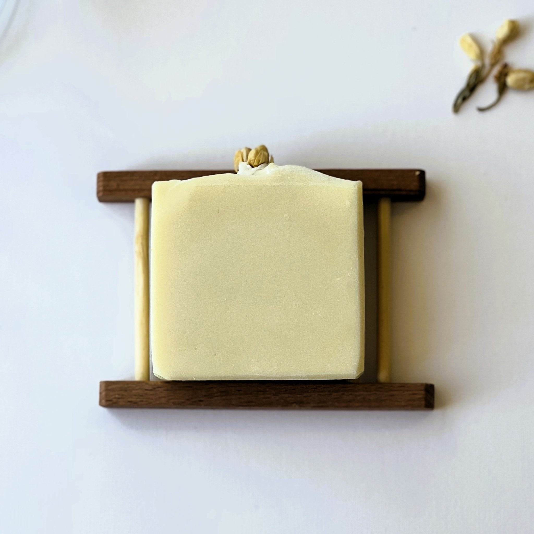 Top-down view of Nuada Naturals Jasmine Drift soap bar topped with dried jasmine