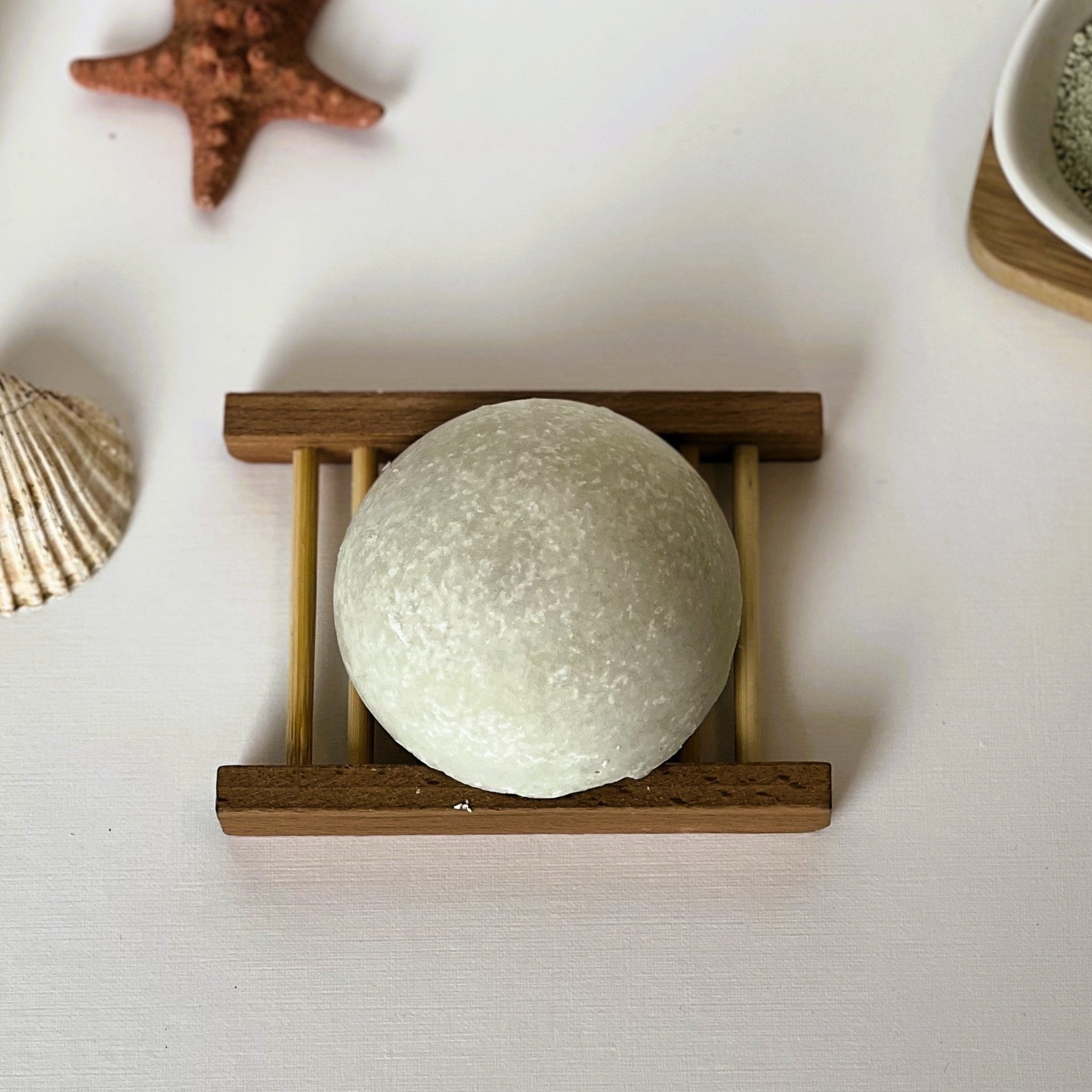 Top-down view of Nuada Naturals Mediterranean Mist pale green round sea salt soap