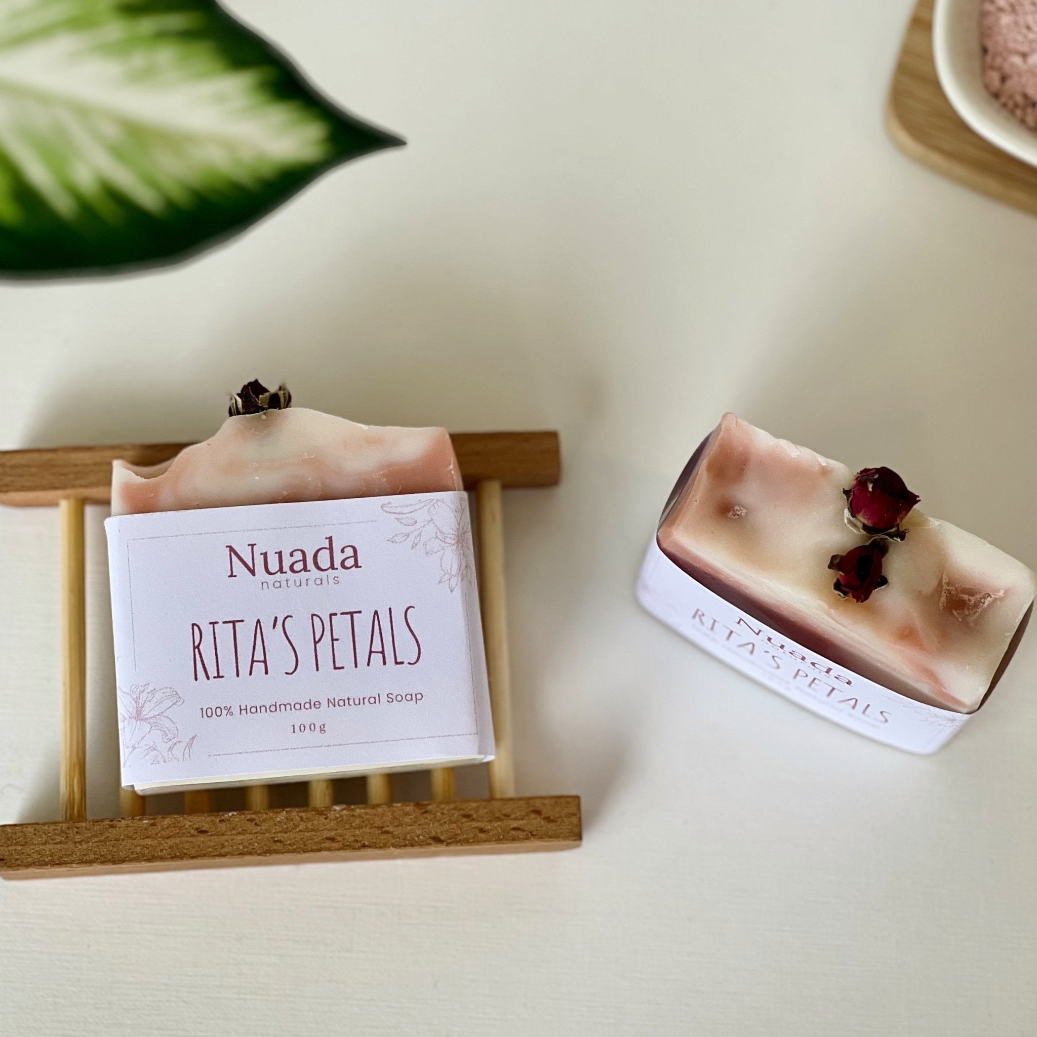 Nuada Naturals Rita's Petals Geranium, Grapefruit & Pink Clay handmade botanical soap bars with dried rosebuds on wooden tray